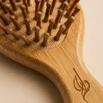Bamboo hairbrush with wooden bristles on a beige background