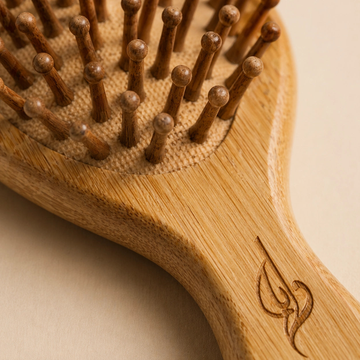 Bamboo hairbrush with wooden bristles on a beige background
