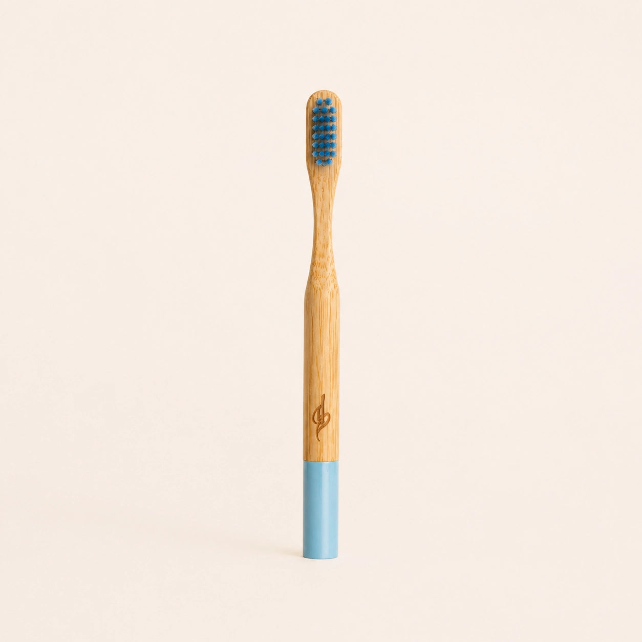 Bamboo toothbrush with blue bristles and handle on a beige background
