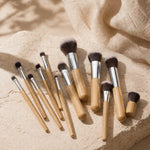 Set of makeup brushes with bamboo wooden handles on a beige fabric background
