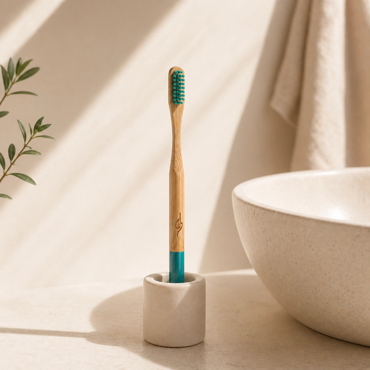 Bamboo toothbrush with green bristles in a white holder on a beige surface.