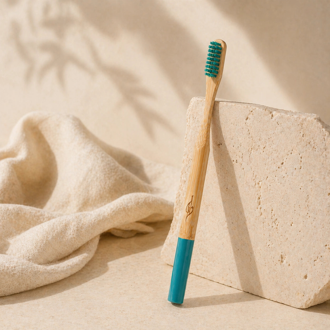 Bamboo toothbrush with blue handle and bristles on a beige background