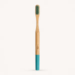 Bamboo toothbrush with green bristles and a blue handle on a white background