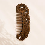sandalwood comb with intricate carvings on a beige background