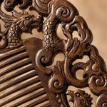 Close-up of a intricately carved sandalwood comb with dragon design