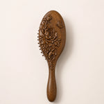 sandalwood hairbrush with floral patterns on a beige background