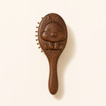 sandalwood kids hairbrush with a cartoon face design on a beige background