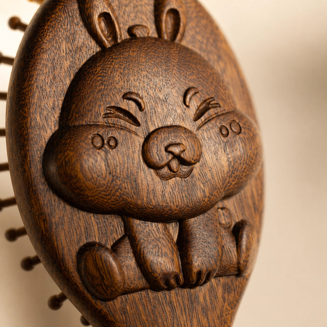 Sandalwood hairbrush with a carved rabbit face on a beige background