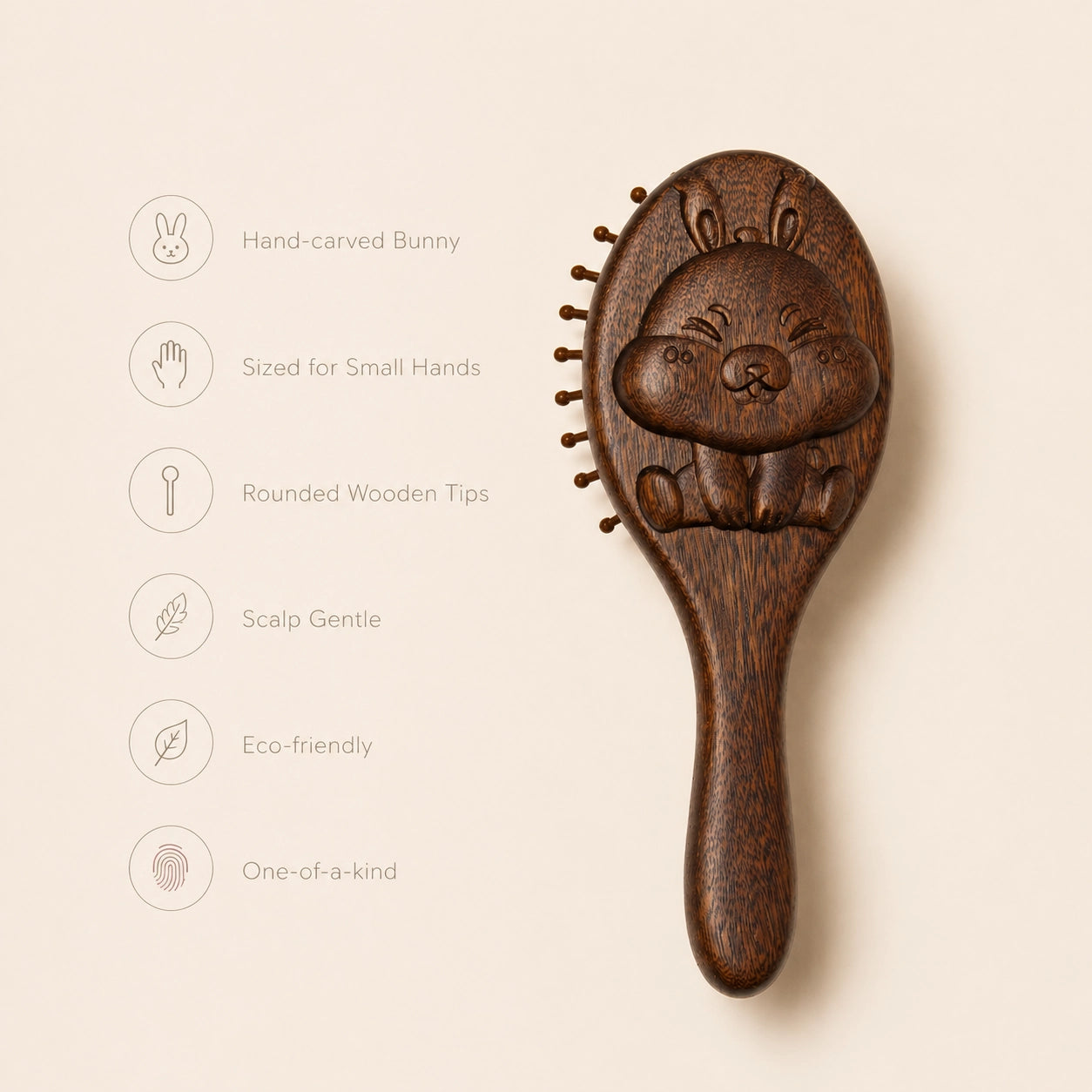 sandalwood hairbrush with bunny design on a beige background with features:
- hand-carved bunny
- sized for small hands
- rounded wooden tips
- scalp gentle
- eco-friendly
- one of a kind