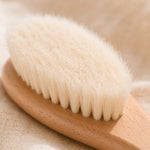 Close-up of a Bamboo newborn brush with natural bristles on a beige background
