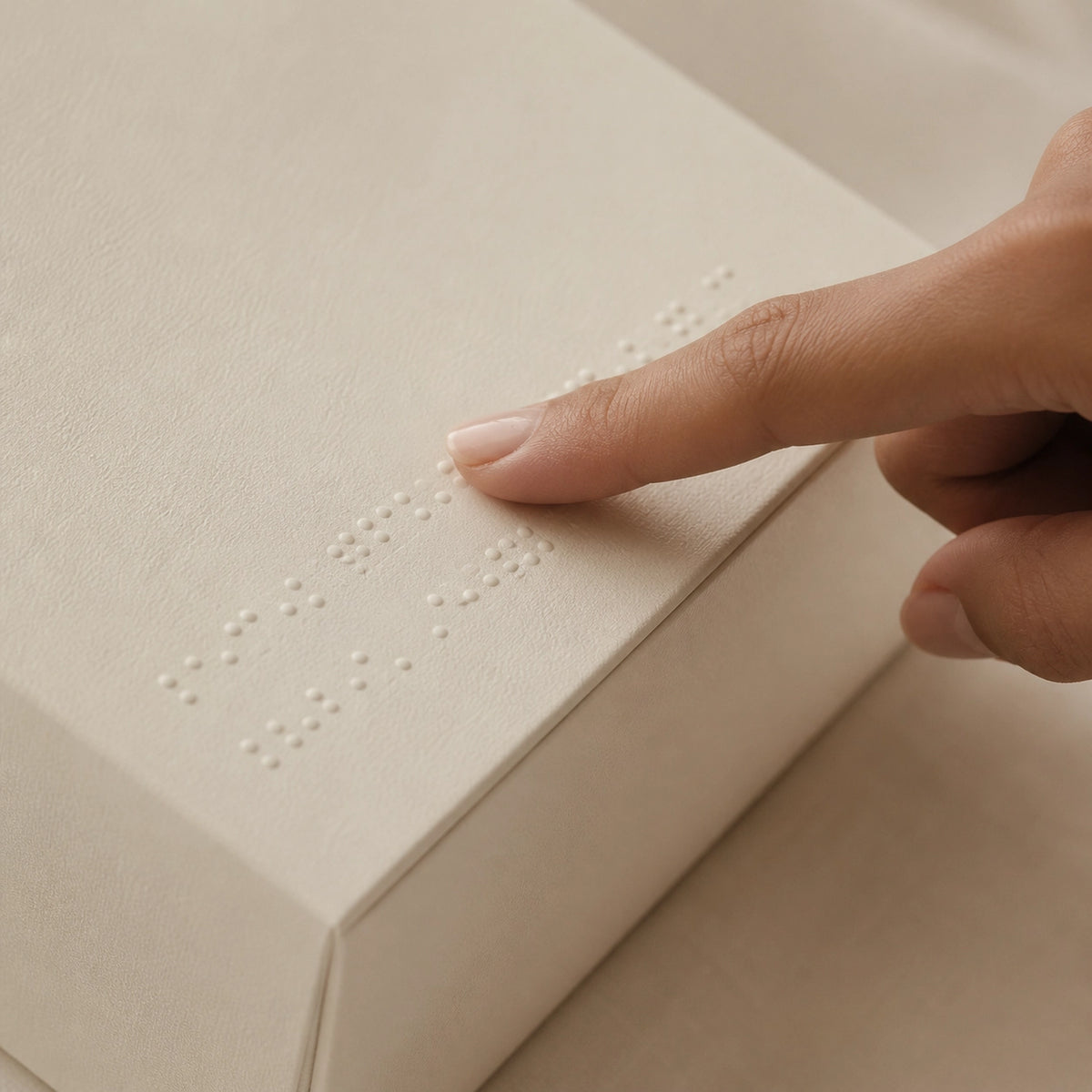 Hand touching a textured surface with raised dots, likely a tactile display.